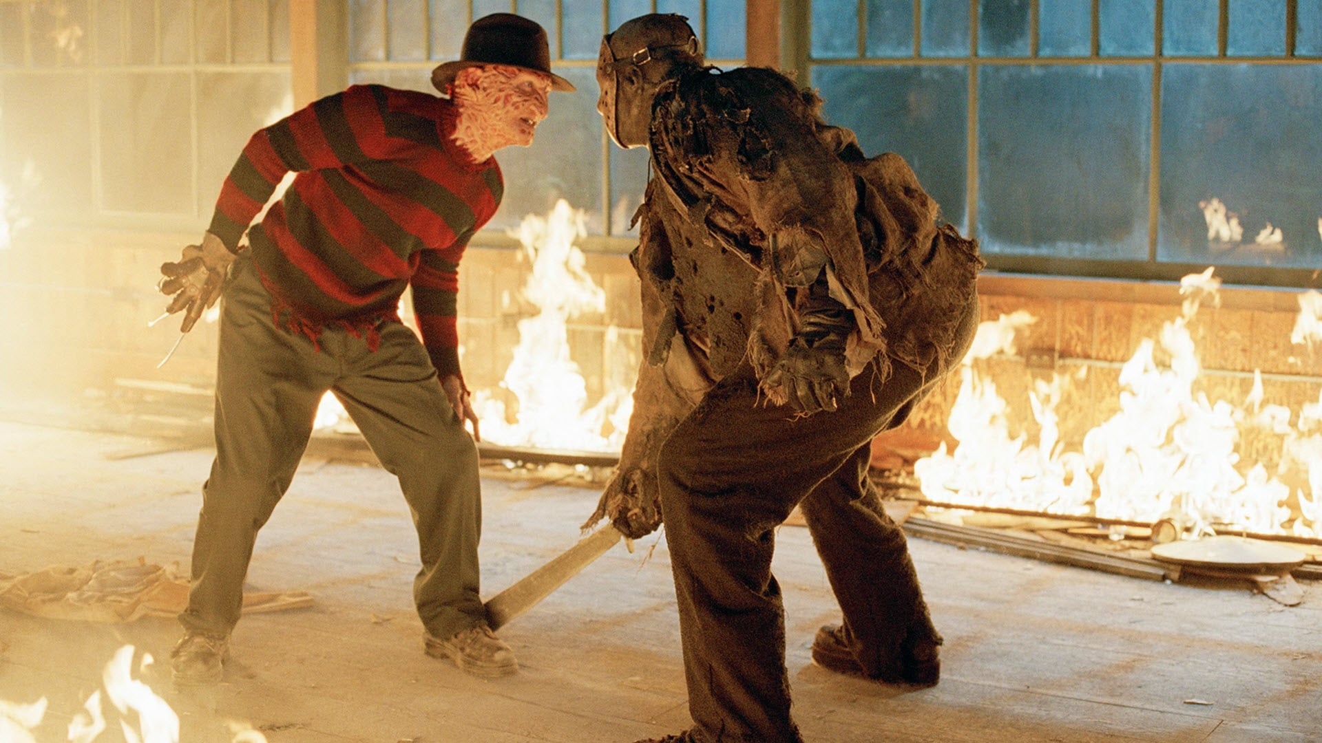 Screenshot from the film Freddy vs. Jason. Freddy Krueger and Jason Voorhees face off in a room surrounded by fire. 
